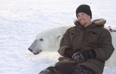 助理教授约翰·怀特曼和一只成年北极熊躺在一起